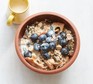 Apricot and hazelnut muesli in a bowl with blueberries on top