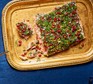 Confit salmon with tahini, pistachio & herb crust served on a gold tray
