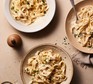 Three plates of creamy garlic pasta