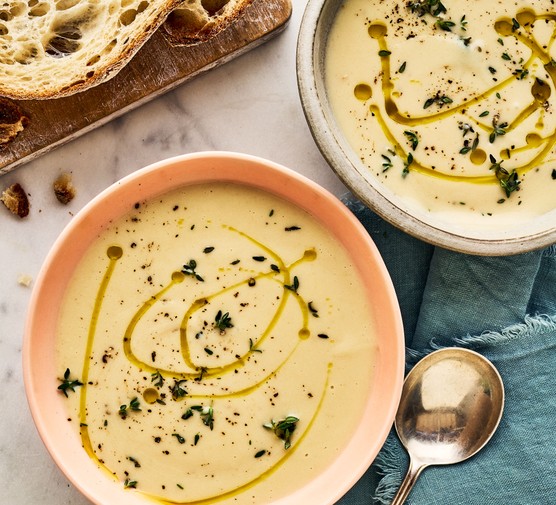 Creamy cauliflower soup served in two bowls with bread