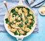 Creamy spinach chicken in a pan with a spoon