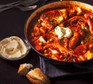 Fish & chorizo stew in a casserole dish with confit garlic aioli