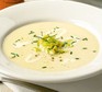 Potato soup in bowl with leeks and cream