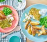 Panko pesto fish served with wedges and peas