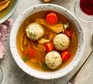Passover chicken soup with horseradish dill matzo balls served in a large bowl