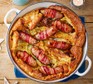 Pot of toad-in-the-hole with sausages wrapped in bacon