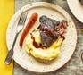 A plate of braised ox cheek and mashed potato, drizzled with a red wine sauce