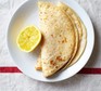 Classic vegan crepes folded on a plate with lemon