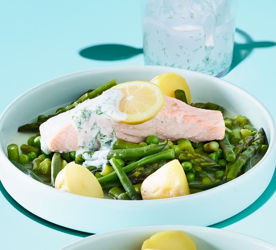 Fillet of steamed trout with lemon slices, on a bed of greens