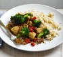 Stir-fried chicken with broccoli & brown rice on a white plate