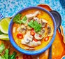 Thai-inspired coconut chicken soup served in a decorative blue bowl